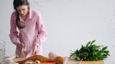 Genç bir çiçekçi kağıt ambalaj çiçekler için hazırlar.