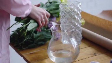 Kız sarı eustomas su bir vazo ekler.