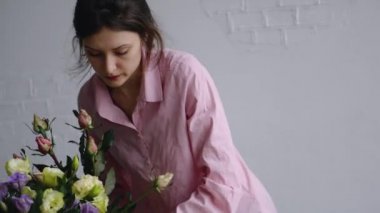 Kız kenarındaki çiçek dolu vazolar yeniden düzenler ve kraft ambalaj kağıt buket için hazırlar