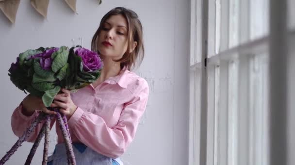 Portrét krásné květinářství s fialovou kyticí neobvyklé - brassica. Podívejte se do kamery. — Stock video