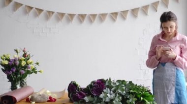 Çiçekçi bir buket siparişi hakkındaki bir müşteri ile bir telefon kullanarak sosyal ağlar üzerinden iletişim kurar.