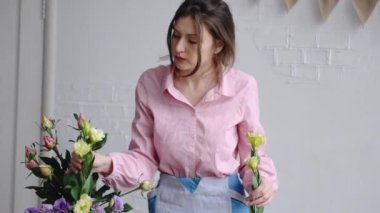 Bir genç Çiçekçi Çiçek eustoma alır ve onları için onun düzenleme inceler