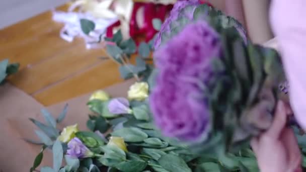 Florista mulher organizando um lindo buquê de flores com brassica — Vídeo de Stock