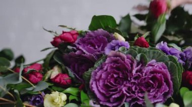 Modern bir buket düzenlenmesi için güzel güller çiçekçi koyar