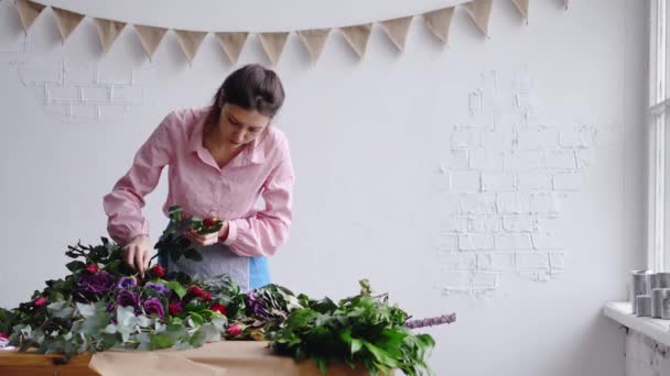 花のコンポジションを作成する集中の若い女性の花屋花を検査します。 — ストック動画