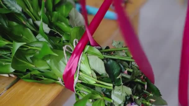 Bloemist bindt van rood lint boeket van bloemen — Stockvideo