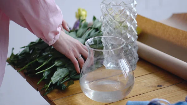 Flicka tar den gula eustomas att sätta dem i vasen — Stockfoto