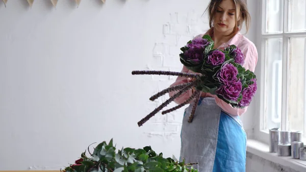 Un florista profesional sostiene flores moradas inusuales —  Fotos de Stock