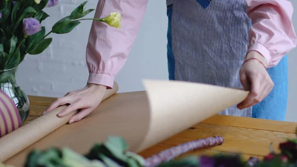 Κορίτσι ξεδιπλώνουν χαρτί kraft για συσκευασία — Φωτογραφία Αρχείου