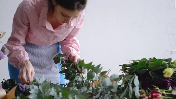 Mujer florista profesional hacer un ramo de hermosas flores con eucalipto —  Fotos de Stock