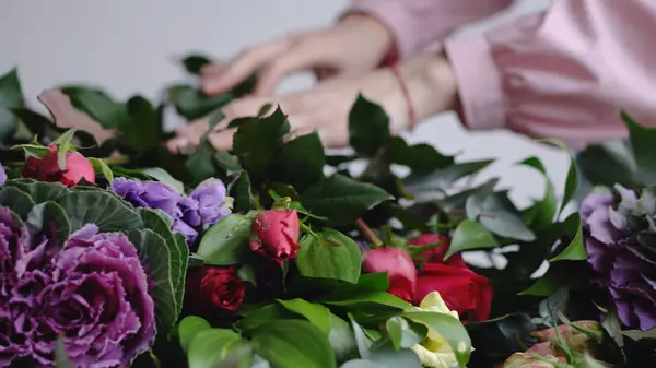 Florist sätter vackra rosor för arrangemanget av en modern bukett — Stockfoto