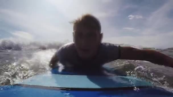 Jeune surfeur attrape une vague et se lève pour surfer dans l'océan à Bali. POV shot 