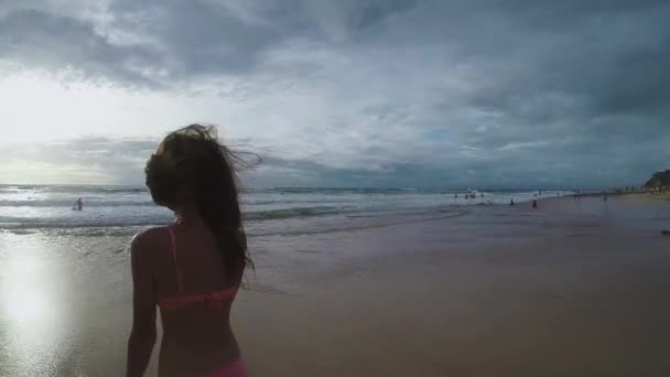 Włosy dziewczyny łopocze na wietrze o zachodzie słońca na plaży w zwolnionym tempie — Wideo stockowe