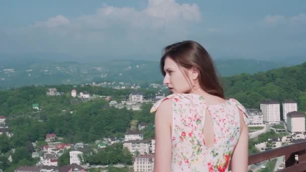 Retrato de una niña en el fondo de una ciudad en las montañas — Vídeo de stock