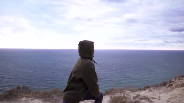 Workout auf einem Felsen, attraktive schlanke Frau beim Stretching in der Natur über dem Meer. Wellnesstraining im Freien in Sportbekleidung — Stockvideo