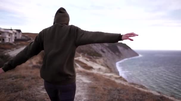 Estilo de vida saudável - uma menina das costas em sportswear está andando no pico da montanha com ventos fortes. Caminhadas de mau tempo — Vídeo de Stock