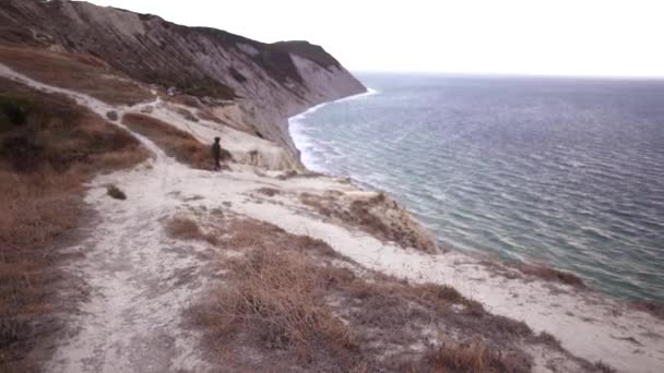 Active woman walks to the edge of a cliff in the distance. Concept of freedom and independence — Stock Video