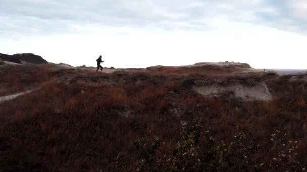 La corredora está entrenando al aire libre - trotando por la mañana temprano en el borde de un acantilado. Vista del dron — Vídeos de Stock