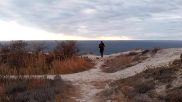 Exercício de bem-estar - atleta mulher corre para a beira de um penhasco. Rastreamento tiro de cima — Vídeo de Stock