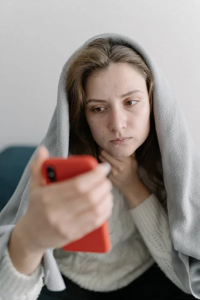 Consulta online del paciente con el médico. Una mujer joven sin maquillaje con una compresa, temperatura y fiebre recibe una recomendación del médico —  Fotos de Stock