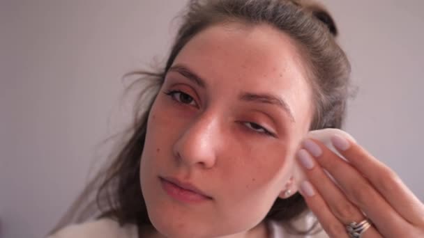 An attractive girl uses a cotton disk with lotion to remove makeup, and then shows the result - dirty cotton pads. Health and Healthy Living — Stock Video