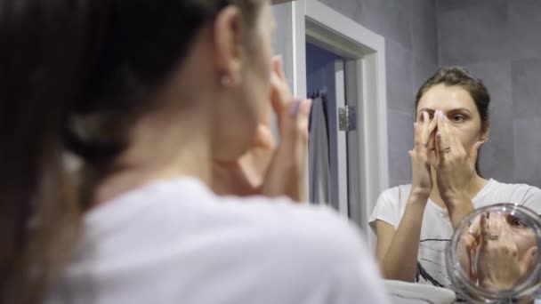 顔のクレンジング。美しい肌を持つ若い女性は顔の衛生に従事しています-泡で毛穴をきれいに — ストック動画
