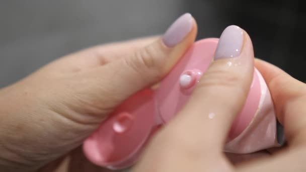 Kobiece dłonie ściskają pianę z rurki w łazience. Kosmetyk, higiena twarzy, zbliżenie kremu do skóry. Koreańskie kosmetyki — Wideo stockowe