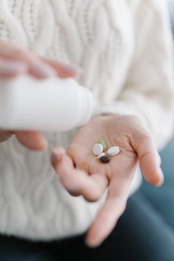 Homeopatik ilaç. Kadın elleri avucunuzun içinde vitamin ve probiyotik hapları açar, yakın plan. Doğal ve zararsız uyuşturucu kavramı
