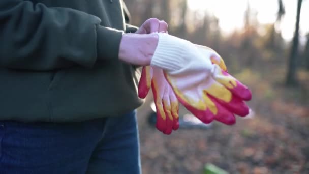 Ženské ruce si nasadí rukavice zblízka. Koncept ochrany životního prostředí, bezpečnosti životního prostředí — Stock video