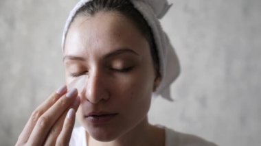 Bir kadın kırışıklıkları düzeltmek ve gözlerinin altındaki deriyi kaldırmak için buz kullanır. Kozmetolojide hidrasyon. Genç ve güzel bir kadının ellerinde eriyen buz