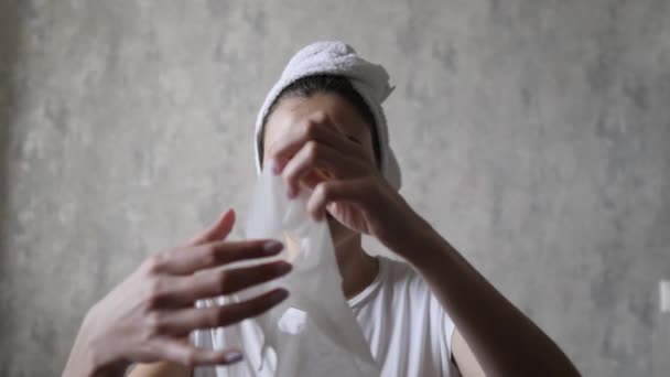 Dívka si doma před prací rozloží hydratační obličejovou masku. Ranní make-up a zvedání obličeje — Stock video