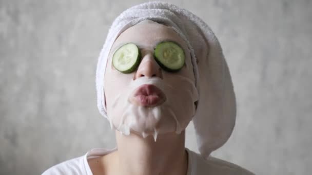 Fun, face care, lifting and hydration. Round cucumbers fall from the eyes of a young beautiful woman — Stock Video