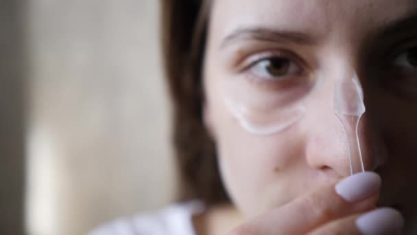 Retrato de close-up de uma mulher cuidado natural da pele usando hidratante. Acariciando um rosto com um pincel para aplicar maquiagem — Vídeo de Stock