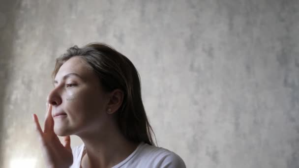 Hermosas pinceladas de corrector beige en una cara de mujer, pómulos y mejillas. Linda chica aplica maquillaje básico en casa — Vídeos de Stock