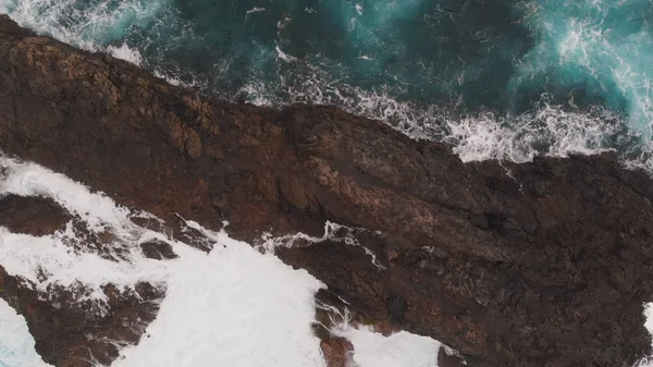 Velké skály ve vodě, vznikající ze zmrzlé lávy. Výhled na ptáky, křišťálový čistý oceán a pěnu u břehů Tenerife. Střela z dronu — Stock fotografie