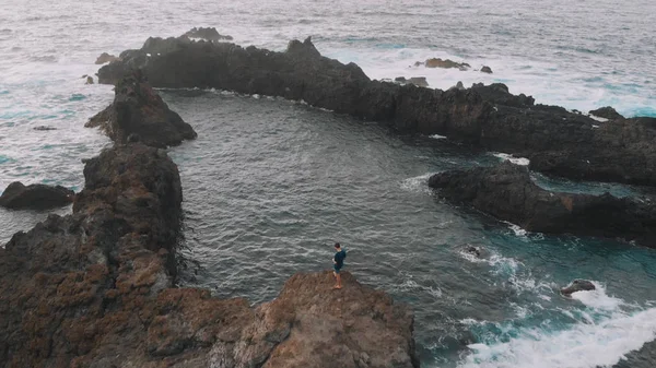 Luchtfoto. Een prachtige baai in de vorm van een driehoek-de man staat op een klif, naast de natuurlijke zwembaden. Tenerife, Canarische eilanden, Spanje — Stockfoto