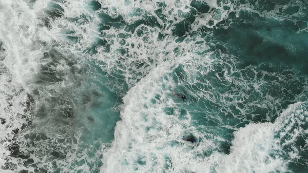 Vista aérea. Dos bodiserfer tratando de nadar a través de las olas gigantes. Vista cinematográfica de arriba a abajo. Deporte extremo. Tenerife, Islas Canarias, España — Foto de Stock