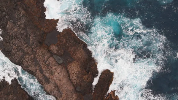 Aerial view - big waves break on the rocky coast of the Atlantic Ocean. A lot of sea foam. Volcanic rocks, Tenerife, Spain — Stock Photo, Image