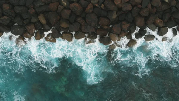 Luftaufnahme - Uferschutz schwarze Steine und das türkisfarbene Meer. gran canaria, spanien — Stockfoto