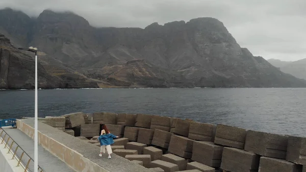 Een vrouw loopt langs gigantische betonnen bescherming stenen van een vogel eye view. Agaete, Gran Canaria — Stockfoto