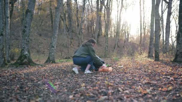 Збирати сміття восени в мішку для сміття. Жінка в лісі рятує природу від руйнування. Світові екологічні проблеми. Широкий статичний план — стокове відео