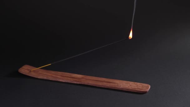 Failed attempt to light an incense stick. Oriental aromatherapy, a subject for feeling harmony and meditation. Black background, static shot. — Stok video