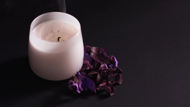 Vela aromática apagada, flores secas con un agradable olor para relajarse en el spa. Primer plano, plano estático sobre fondo negro, aislado — Vídeos de Stock