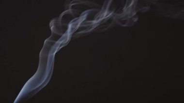 Beautiful white smoke in isolation on a black background slowly moves upwards