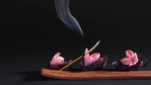 Meditation and relaxation. Items for yoga classes. Static shot against a dark background, aroma wand and flowers — Stok video