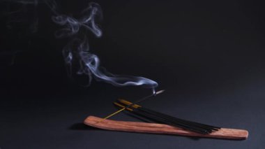 Therapeutic oriental smoke. Aromatherapy, relaxation and yoga. Smoke from aroma sticks moves on a black background