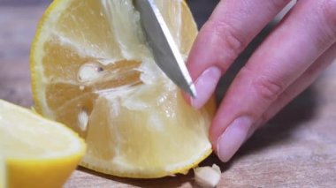 Tahta bir tahtanın üzerinde büyük bir bıçakla sulu bir limonu dilimlemek. Sağlıklı vejetaryen yemekleri, Meksika kültürü. Organik narenciye, yakın çekim, statik çekim