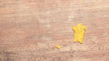 One yellow triangular nachos are eaten stop motion timelapse. Fast food and high-calorie food. Chips for snacking