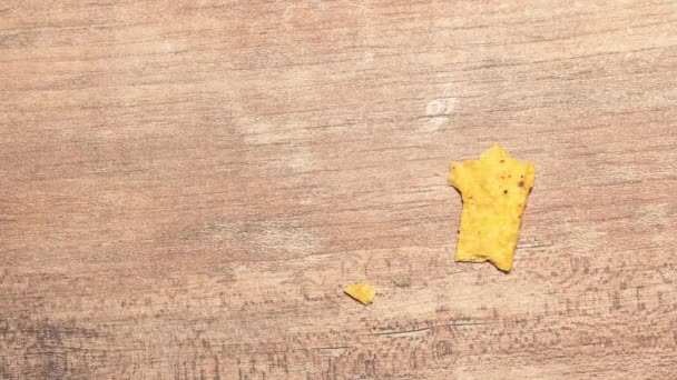 One yellow triangular nachos are eaten stop motion timelapse. Fast food and high-calorie food. Chips for snacking — Wideo stockowe