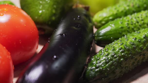 El agua gotea en un grupo de verduras, berenjena en el centro. Productos veganos frescos de cerca. Dieta para un estilo de vida saludable — Vídeo de stock